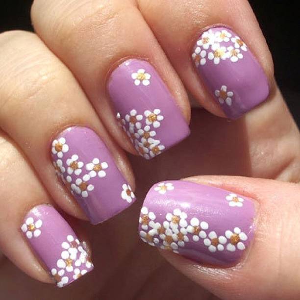 Nail art con fiori fai da te fiorellini bianchi su fondo lilla
